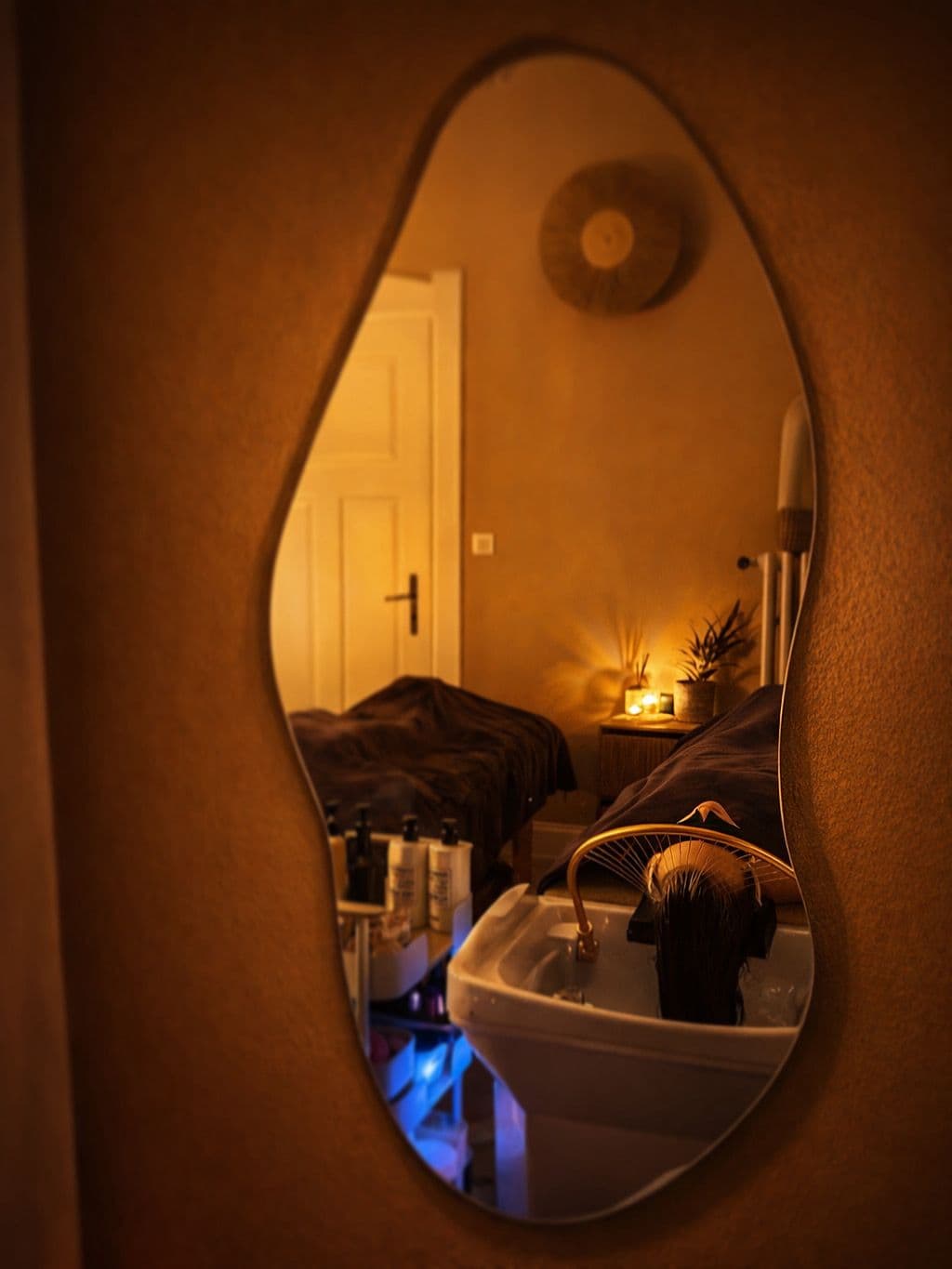 Cabine de soin chez L'Instant Précieux Thionville : miroir organique, table de massage, bougies et bac Head Spa